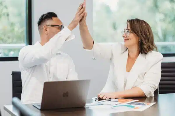 Two owners high-fiving after a successful planning session.