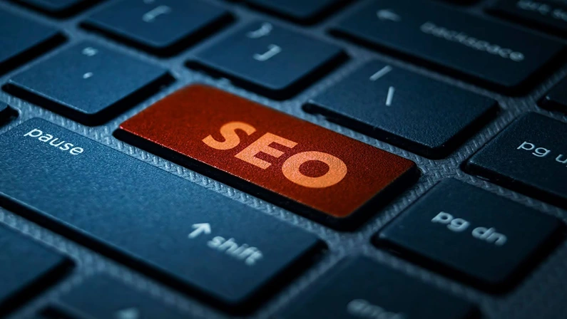 Close-up of a black computer keyboard with a red key labeled "SEO," symbolising search engine optimisation and digital marketing strategies.